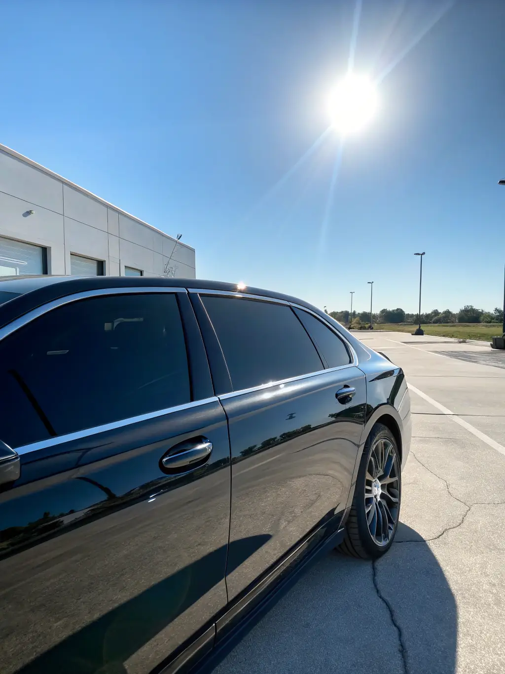 Image of a sleek car with professionally tinted windows, parked in front of the Teintérior garage, showcasing the enhanced style and privacy.